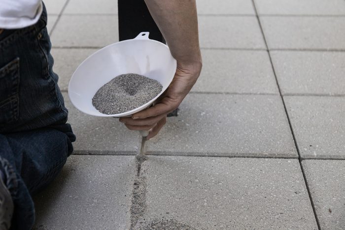 Pouring Jointing Sand in Paver Patio Installation
