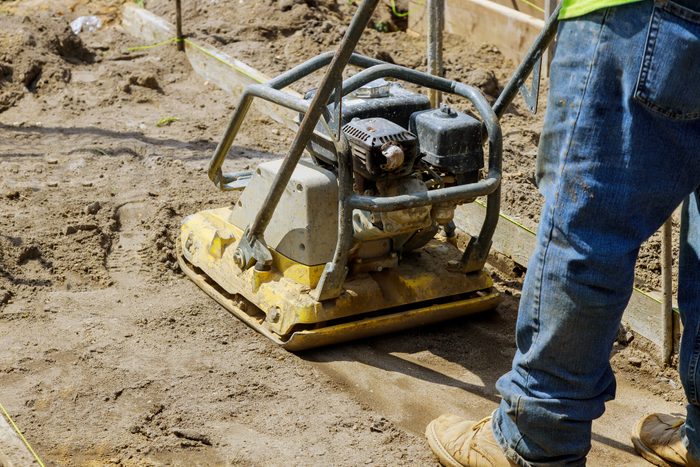 Plate compactor on under construction on new pavement