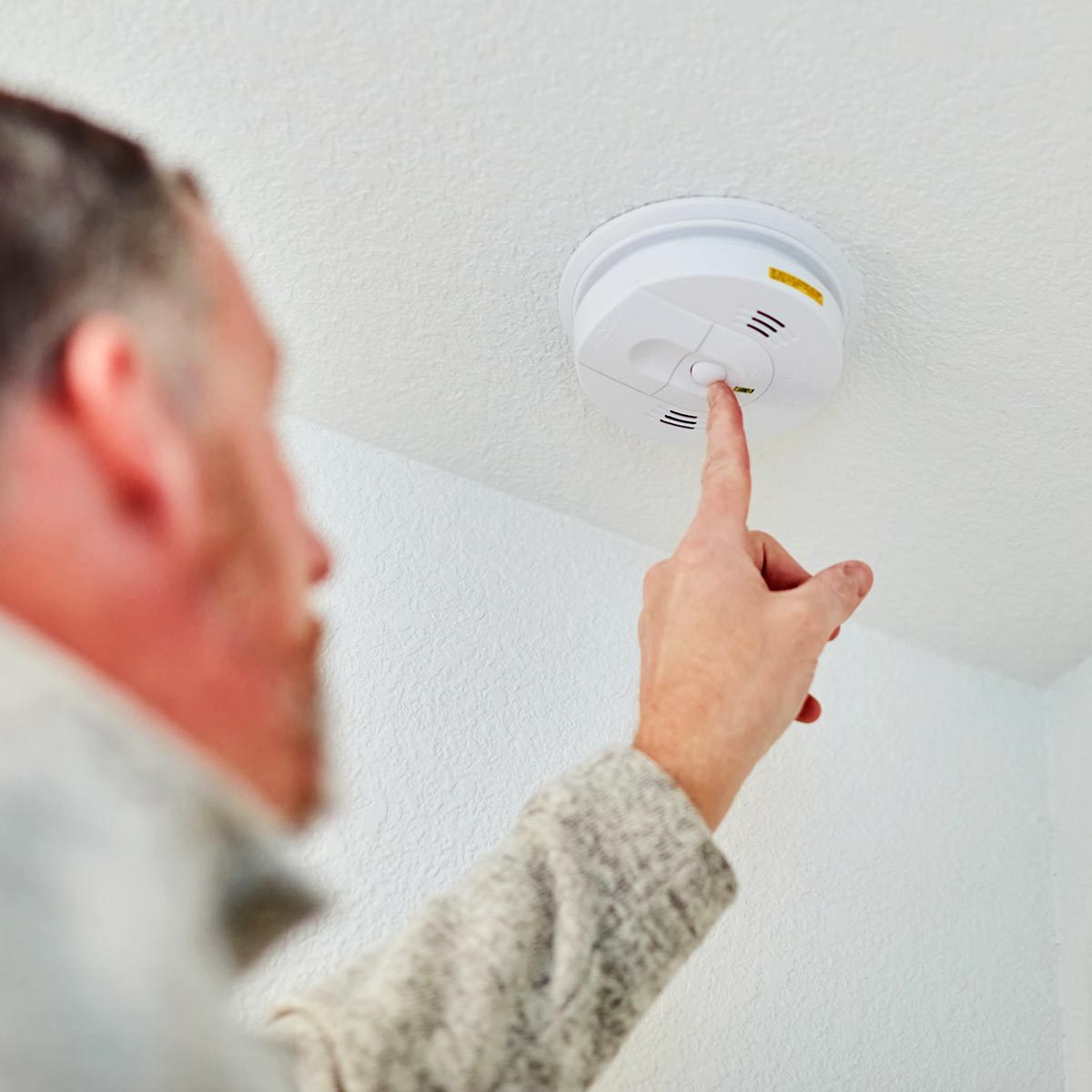A person switching off the fire alarm