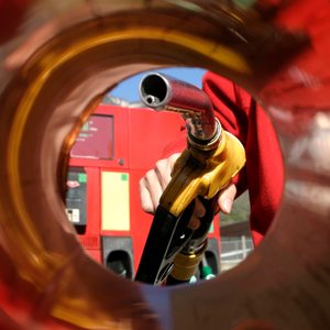 View from inside a car's gas tank intake with a gas pump entering it